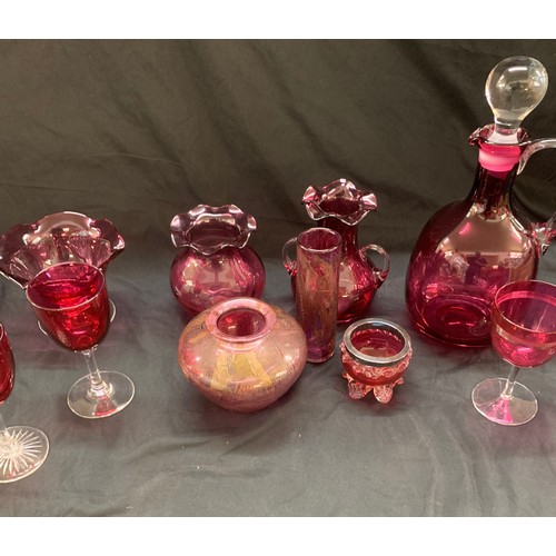 24 - Selection of cranberry glass ware to include a decanter, jugs, trifle dishes etc