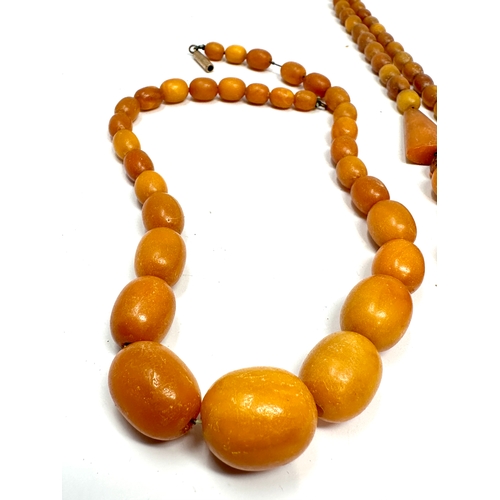 98 - 2 antique egg yolk amber bead necklaces weight 42g