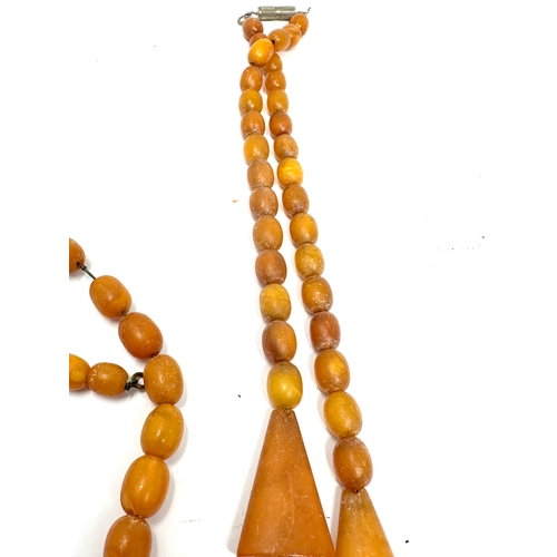 98 - 2 antique egg yolk amber bead necklaces weight 42g