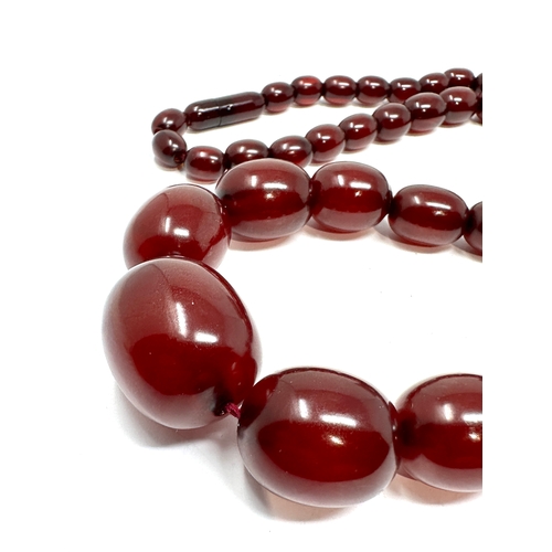99 - Cherry amber / bakelite bead necklace with internal streaking largest bead measures approx 27mm by 2... 
