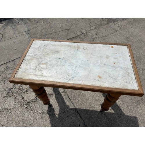 385 - Beech Edwardian table on castors measures approx 38 inches long, 21 wide and 30 tall