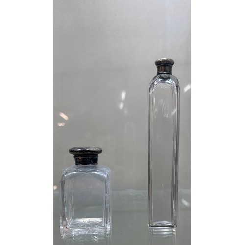 556 - 4 Silver topped glass bottles, tallest measures approximately 7 inches