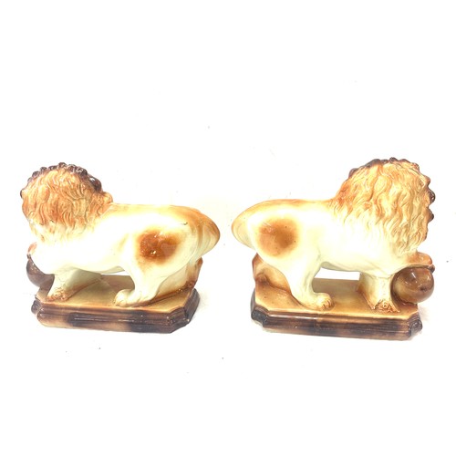 273 - Pair of Staffordshire lions 1920's glass eyes, paw on balls. By Lancaster and Sons LTD. Hanley Staff... 