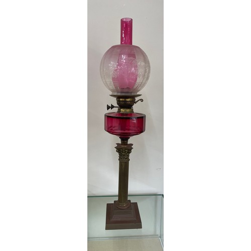 312 - Antique column base oil lamp with cranberry glass, total height 30 inches