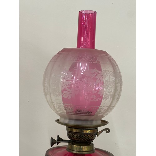 312 - Antique column base oil lamp with cranberry glass, total height 30 inches