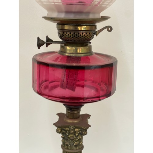 312 - Antique column base oil lamp with cranberry glass, total height 30 inches