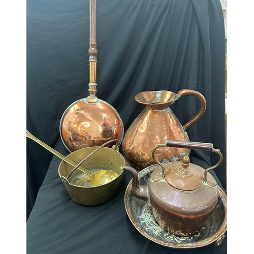 97 - Selection of copper and brassware to include a bed warming pan, large jug, kettle etc, jug measures ... 