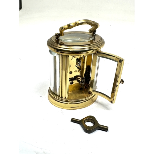 446 - brass carriage clock the clock is in working order measures approx 8cm high not including handle bow... 