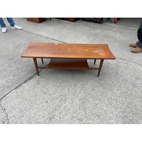 298 - 1960's teak coffee table with magazine rack measures approx 14 inches tall, 48 long and 16 deep