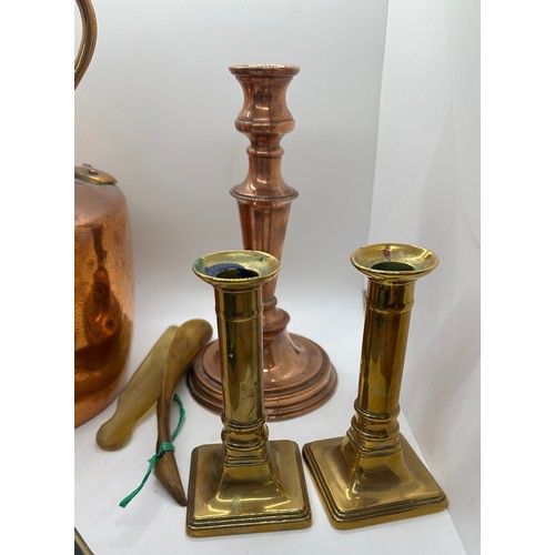 59 - Selection of metal ware to include a copper kettle and candle stick, pair of brass candle sticks and... 