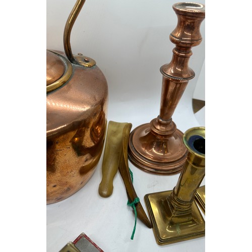 59 - Selection of metal ware to include a copper kettle and candle stick, pair of brass candle sticks and... 