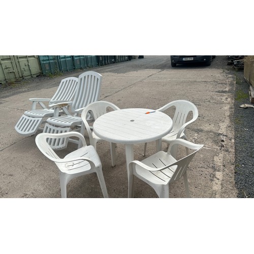 100E - Plastic outdoor table and for chairs along with two plastic outdoor lounging chairs