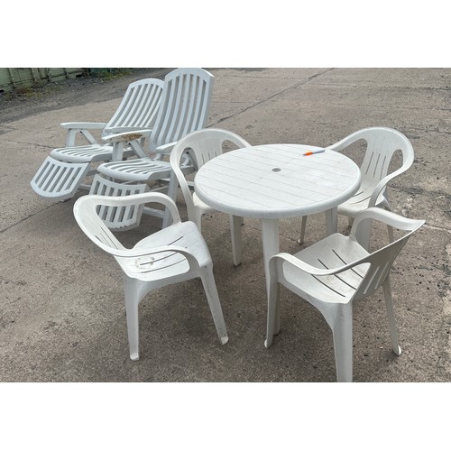 100E - Plastic outdoor table and for chairs along with two plastic outdoor lounging chairs