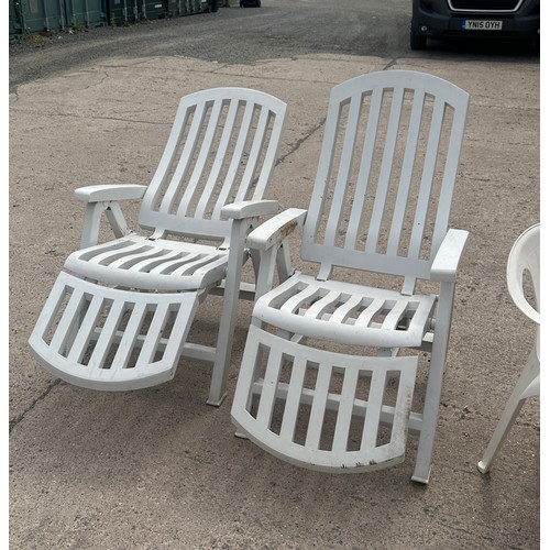 100E - Plastic outdoor table and for chairs along with two plastic outdoor lounging chairs