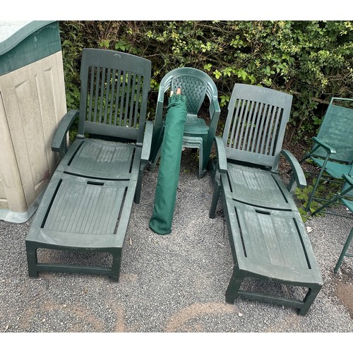 100M - Two plastic sun loungers and four green plastic chairs