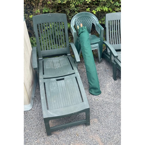 100M - Two plastic sun loungers and four green plastic chairs