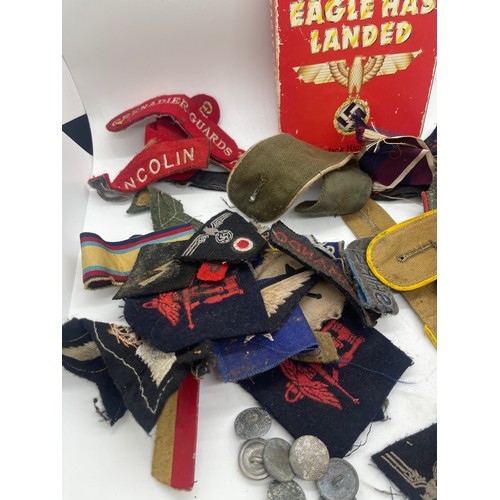 555 - Tin containing a quantity of WW2 era cloth patches including NZ airforce, Royal Winnipeg rifles, gre... 