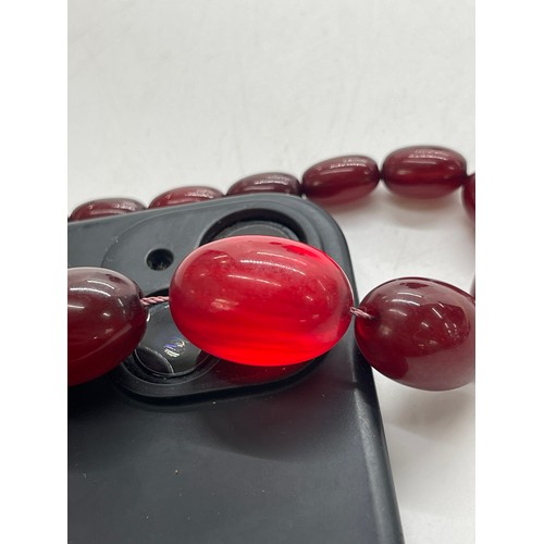 496 - Vintage cherry red amber bakelite beads weigh approx 34 grams with internal streaking and another ne... 