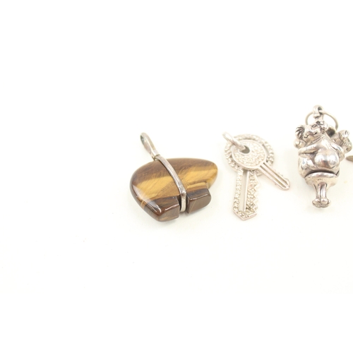 435 - A collection of novelty silver pendants including a touchwood (57g)