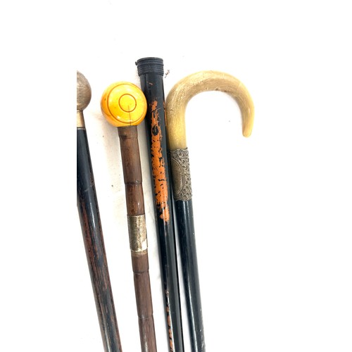 60 - Four silver topped walking sticks