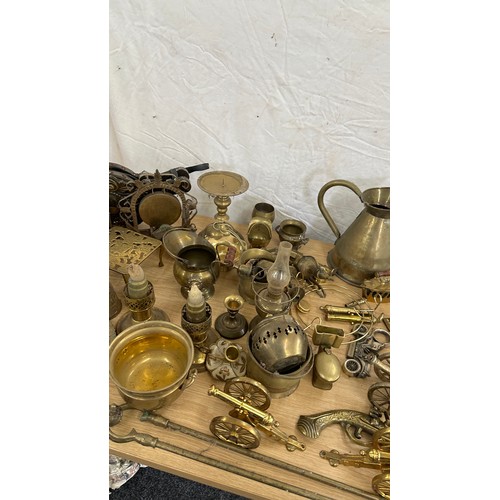 102 - Large selection of brass ware items to include jugs, ornaments, oil lamps, canons, egg timer etc