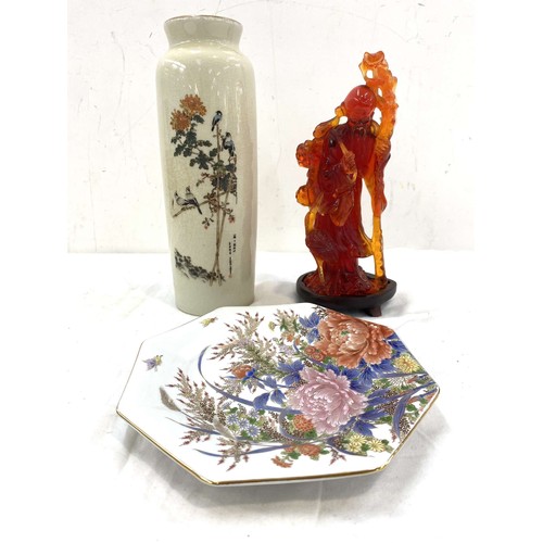 68 - Three pieces of oriental items to include a plate, vase and an amber figure with wooden stand, maker... 