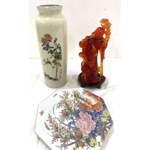 68 - Three pieces of oriental items to include a plate, vase and an amber figure with wooden stand, maker... 