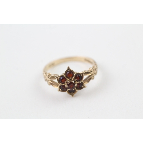 219 - 9ct gold garnet dress ring with patterned shoulders (2.4g)