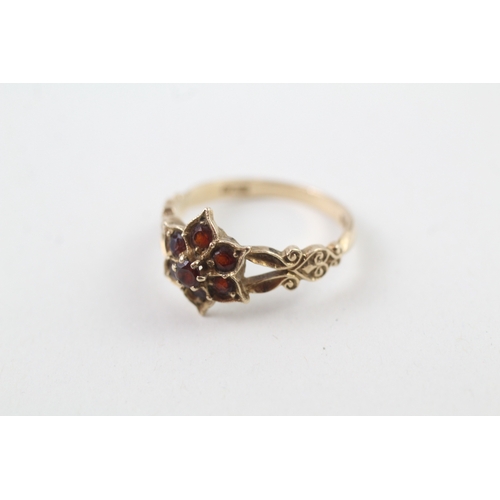 219 - 9ct gold garnet dress ring with patterned shoulders (2.4g)