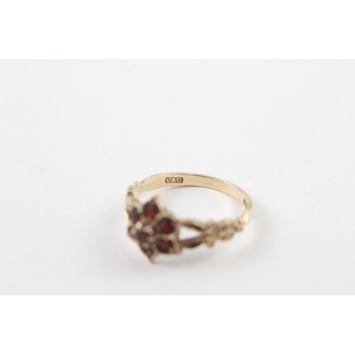 219 - 9ct gold garnet dress ring with patterned shoulders (2.4g)