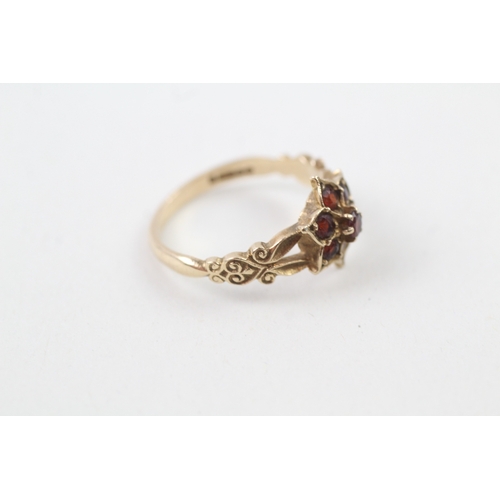 219 - 9ct gold garnet dress ring with patterned shoulders (2.4g)