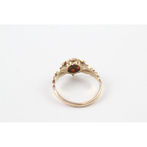 219 - 9ct gold garnet dress ring with patterned shoulders (2.4g)