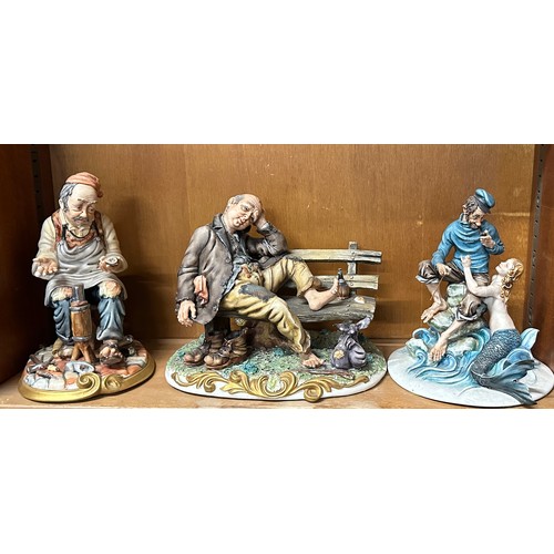 104 - Three Capodimonte figures one homeless man on bench, a Ship Captain and Mermaid etc