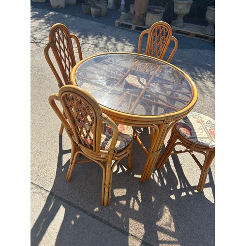 492 - Cane glass top table and 4 chairs, approximate measurements: Height 31 inches, diameter 39 inches