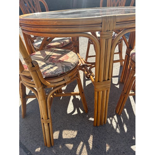 492 - Cane glass top table and 4 chairs, approximate measurements: Height 31 inches, diameter 39 inches