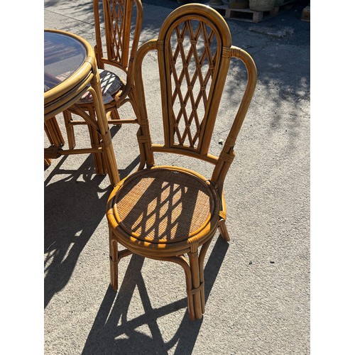 492 - Cane glass top table and 4 chairs, approximate measurements: Height 31 inches, diameter 39 inches