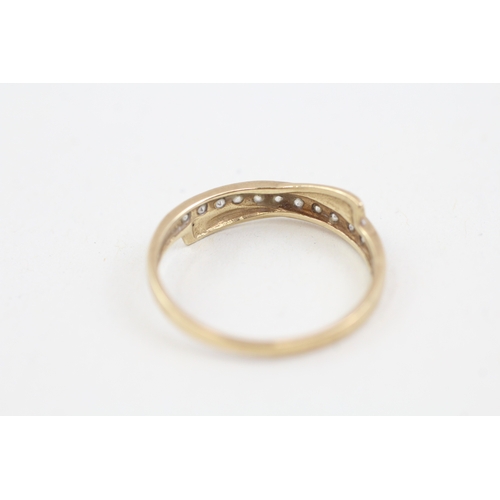 129 - 9ct gold cubic zirconia set crossover band ring (1.5g)