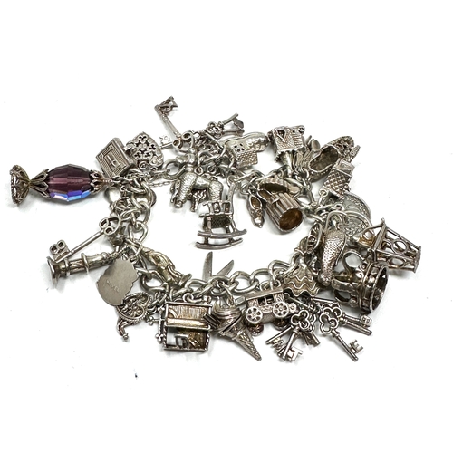 265 - Heavy vintage silver charm bracelet and charms with opening charms weight 92g