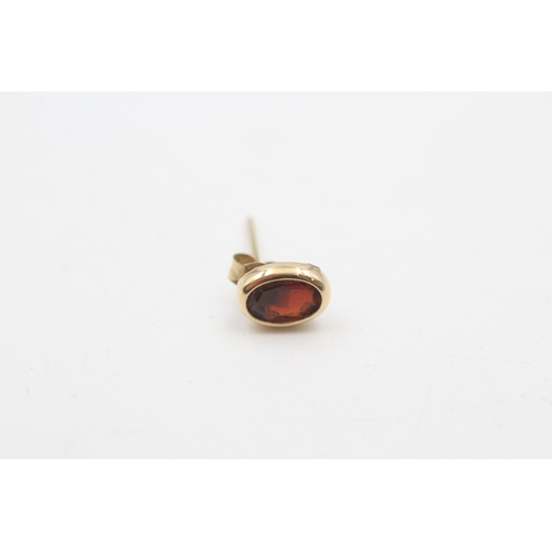 201 - 9ct gold oval cut garnet stud earrings (0.7g)