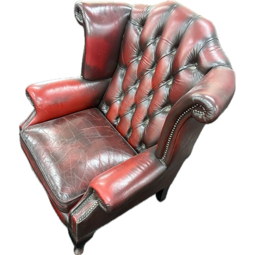 389 - Ox blood leather Chesterfield wingback chair with footstool, approximate measurements: Height 40 inc... 