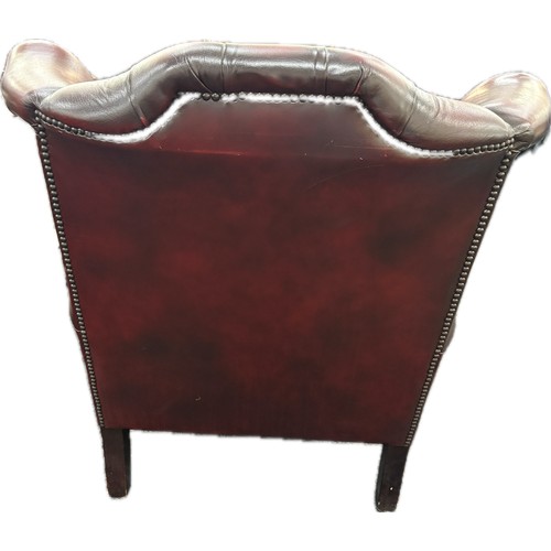 389 - Ox blood leather Chesterfield wingback chair with footstool, approximate measurements: Height 40 inc... 