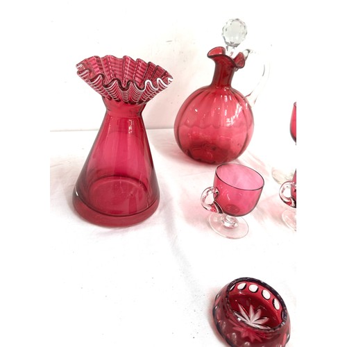 26 - 7 pieces of Cranberry glass to include a decanter, vase, salt and pepper pots, cups etc