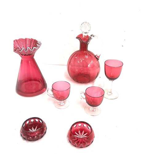 26 - 7 pieces of Cranberry glass to include a decanter, vase, salt and pepper pots, cups etc