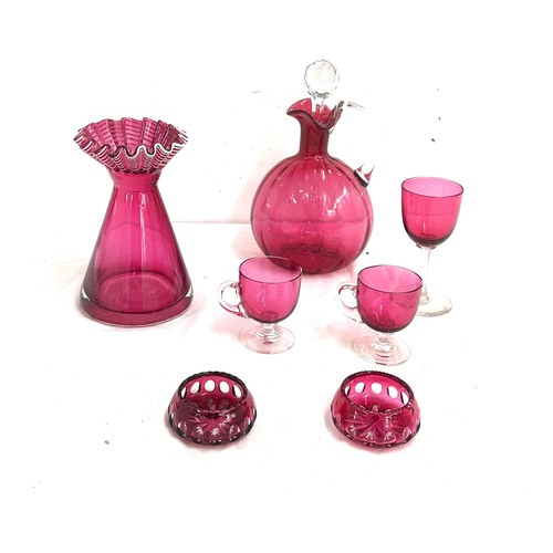 26 - 7 pieces of Cranberry glass to include a decanter, vase, salt and pepper pots, cups etc