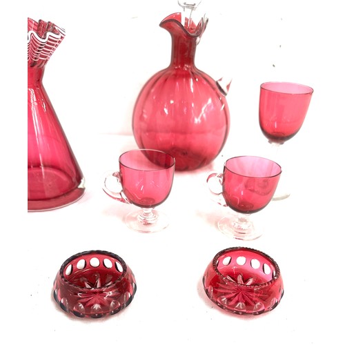 26 - 7 pieces of Cranberry glass to include a decanter, vase, salt and pepper pots, cups etc