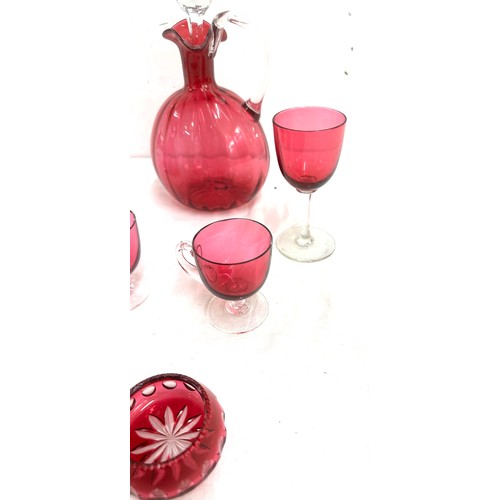 26 - 7 pieces of Cranberry glass to include a decanter, vase, salt and pepper pots, cups etc