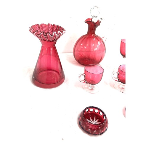 26 - 7 pieces of Cranberry glass to include a decanter, vase, salt and pepper pots, cups etc