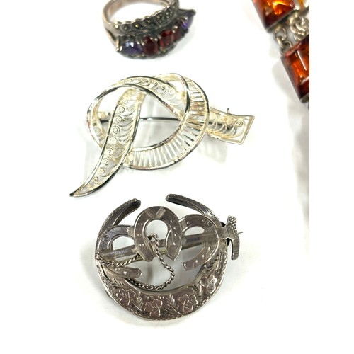 586 - Selection of silver jewellery includes amber bracelet, brooches, ring etc