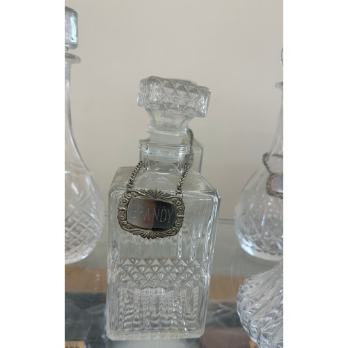 125 - Selection of glass ship decanters with tags