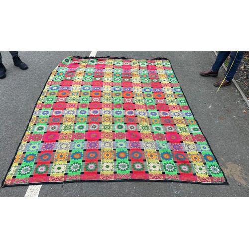 179 - Large hand knitted floral throw measures approximately 95 inches long by 75 wide